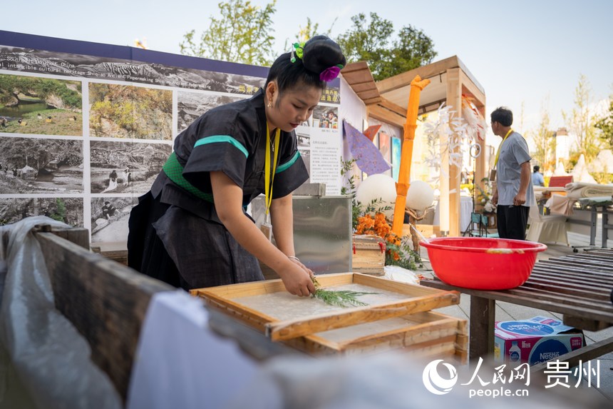 山地生活消費(fèi)與非遺傳承展現(xiàn)場，非遺技藝丹寨古法造紙傳承人展示古法造紙技藝。人民網(wǎng) 涂敏攝