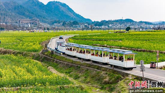 游客在金海雪山景區(qū)乘坐小火車。