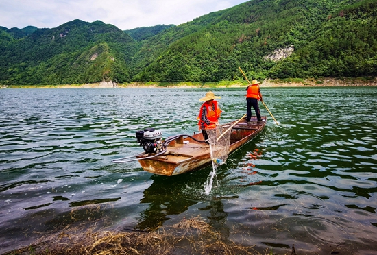 （供稿）貴州甕安持續(xù)推進(jìn)烏江流域水生態(tài)文明建設(shè)_fororder_甕安縣珠藏鎮(zhèn)豐巖村村民盧錫永、冉戌英夫婦駕駛小船打撈江面垃圾（盧錫江 攝）