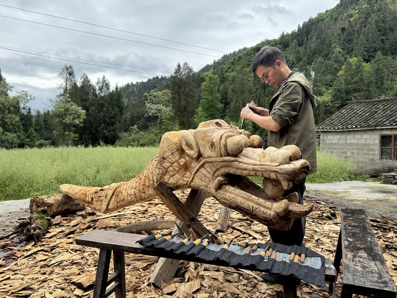 近日，碧江區(qū)和平鄉(xiāng)陳家寨村村民在制作龍舟龍頭，為端午節(jié)龍舟賽做準(zhǔn)備。 申逸愷攝