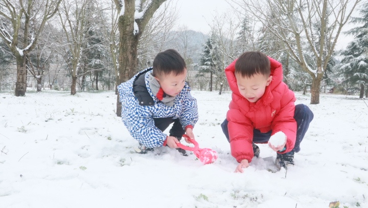 兩個小朋友玩雪。 稅會靜攝