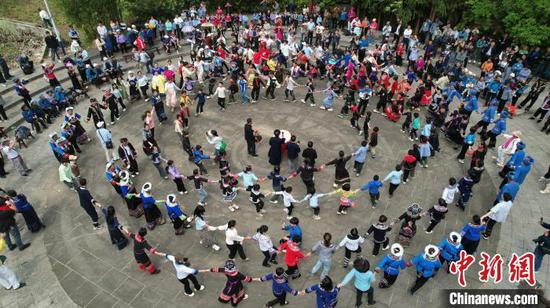 圖為航拍貴州冊(cè)亨大寨村布依群眾歡慶傳統(tǒng)節(jié)日“三月三”，村民嘉賓一起跳布依轉(zhuǎn)場(chǎng)舞。葉方杰 攝