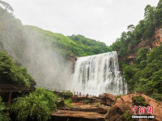 5月27日，游客在赤水丹霞旅游區(qū)·赤水大瀑布前拍照打卡。